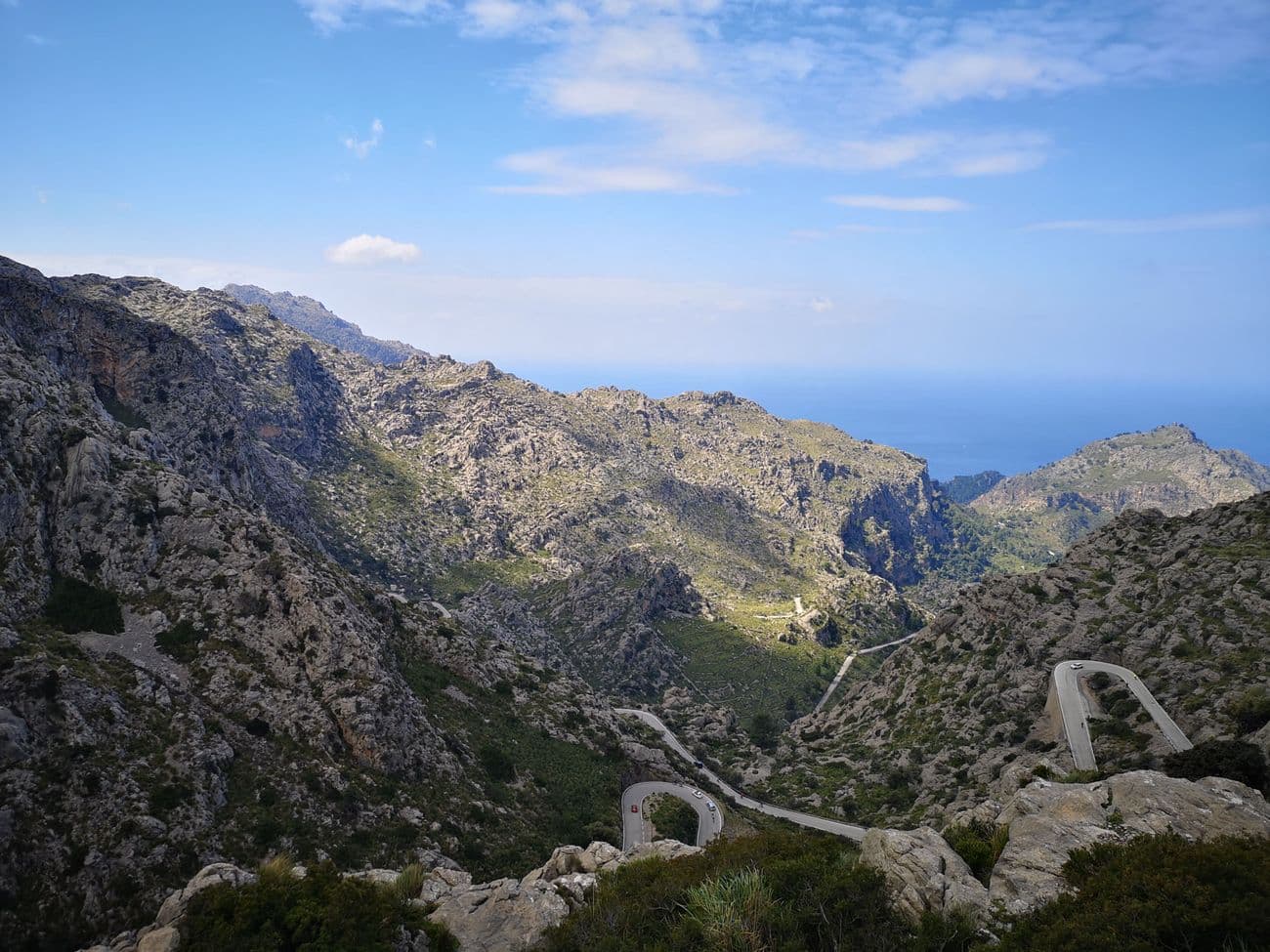 Hairpin bends of the Sa Calobra road winding down through the bare limestone of the Serra de Tramuntana, the sea beyond.