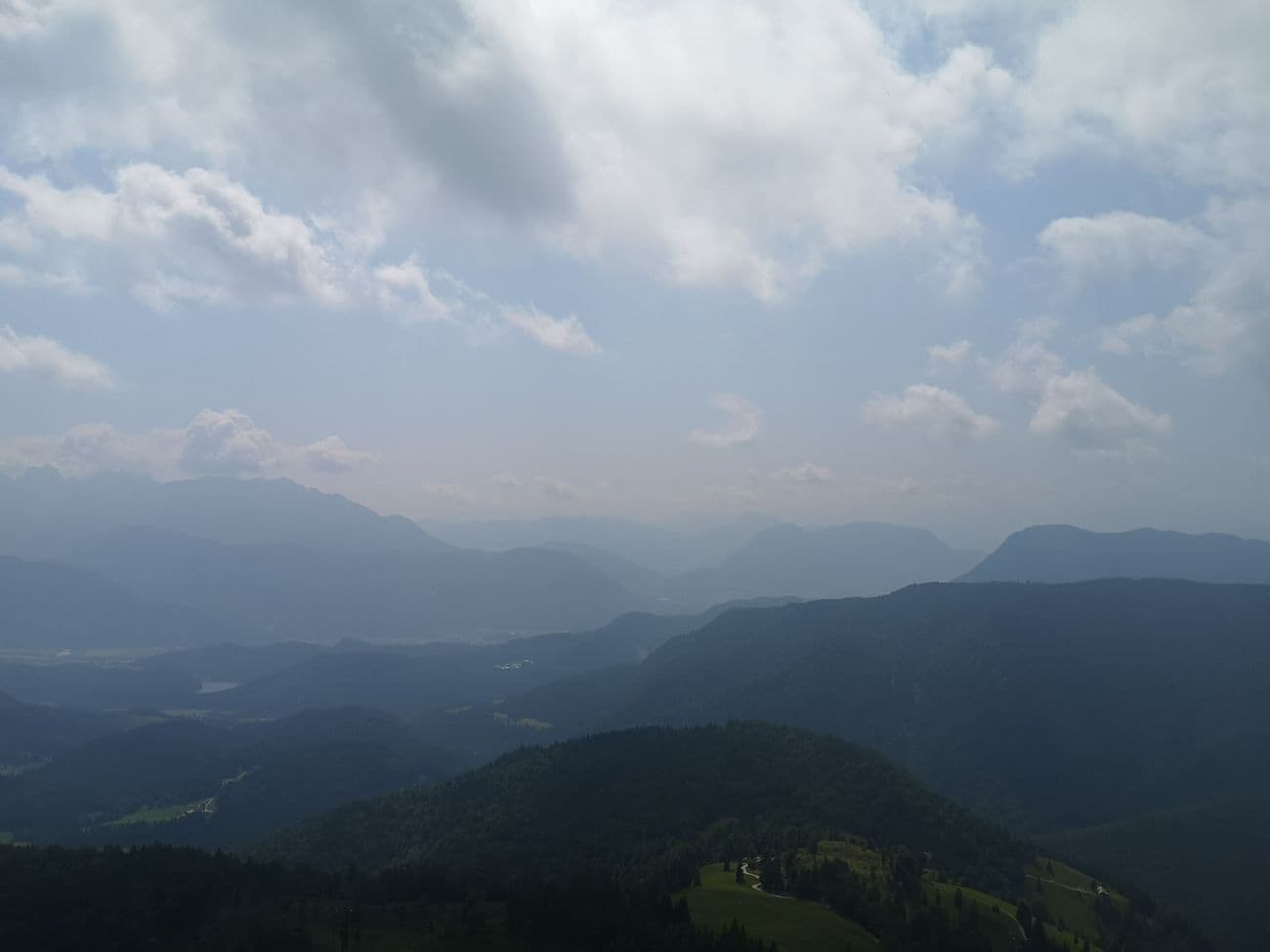 Layered mountain ridges receding into haze over the Inn valley, seen from high on the Brünnstein.